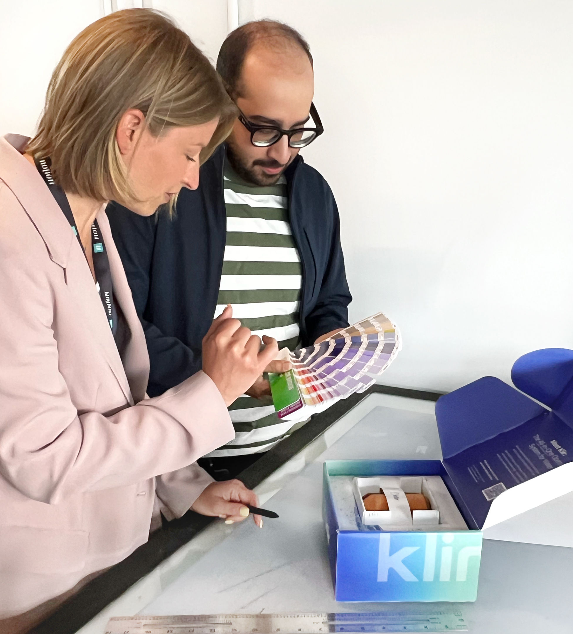 Colleagues evaluating colour swatches during print production planning.